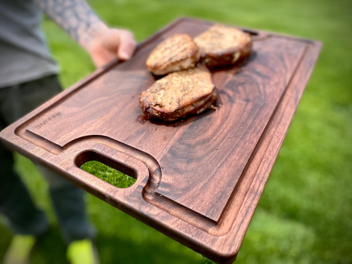 Reversible walnut cutting board with handles and juice groove, 18 by 12 inches